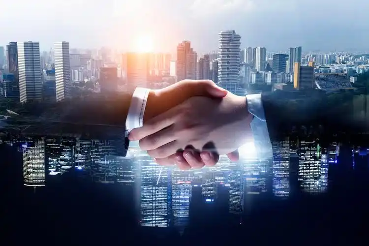 在城市背景下两位商务人士正在握手合作团结握手企业团结团结人物合作