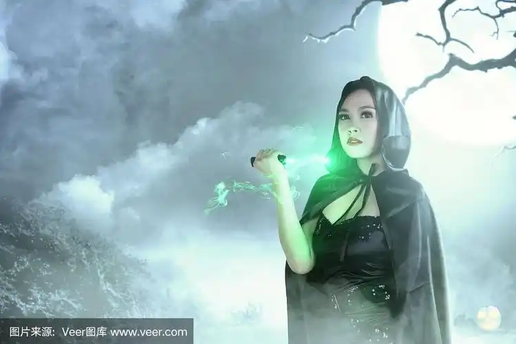 亚洲女巫师在黑色兜帽做仪式魔术与刀