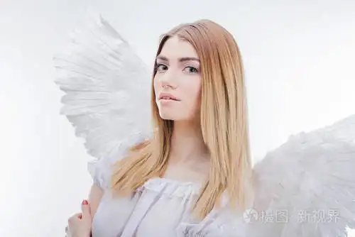 一位天使从天堂.在白色翅膀的天使形象年轻, 精彩的金发女郎