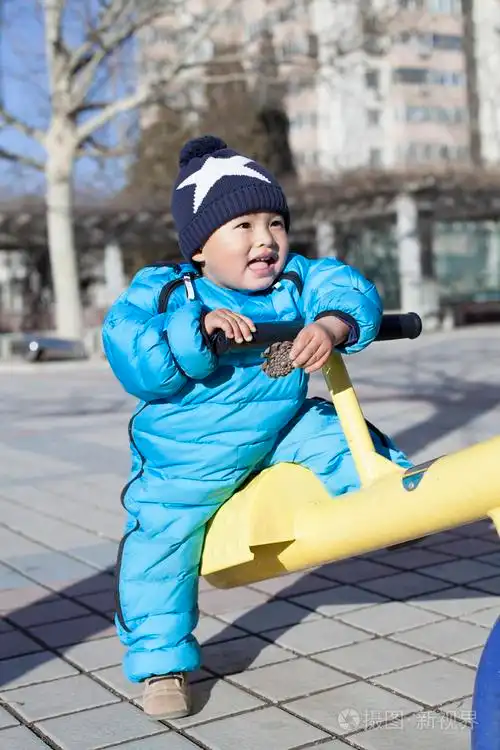 可爱的中国小男孩玩跷跷板户外