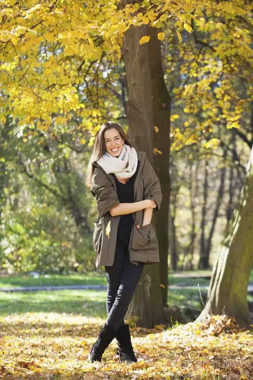 女人走在秋天的公园