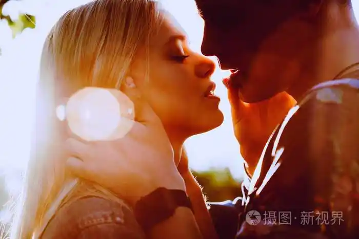 可爱的年轻白人夫妇拥抱和亲吻太阳