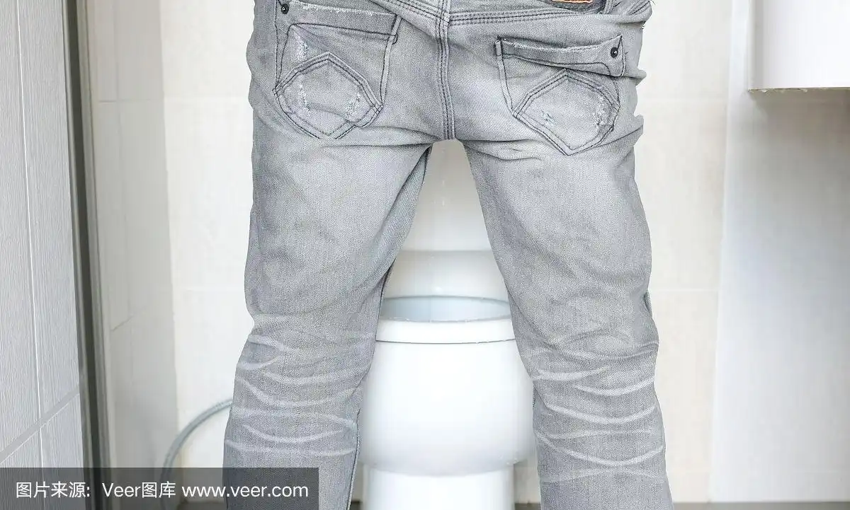 后视图男人站在家里厕所里对着马桶撒尿.健康的概念