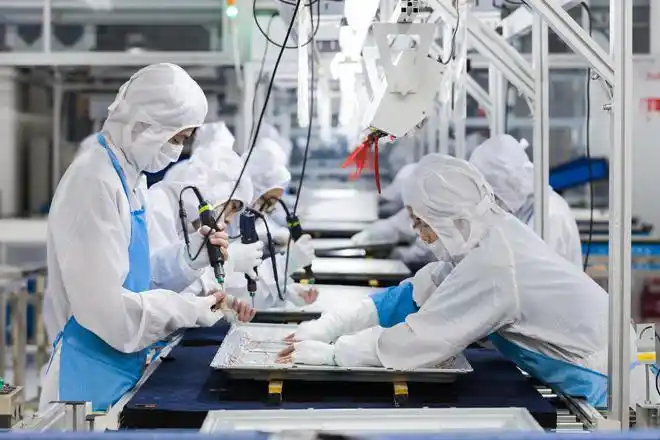 工人在位于山东青岛的海信信息产业园电视组装生产线上工作(资料照片)