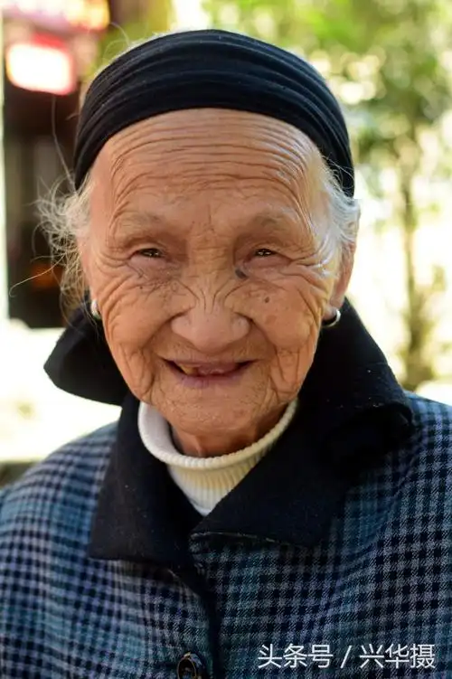 90岁的邓长梅老人慈眉善目,和蔼可亲.古村里的老人大都长寿.