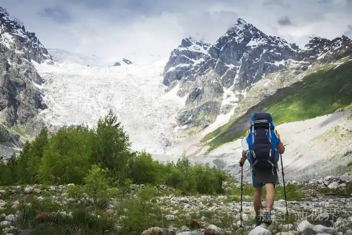 徒步旅行在山上.登山者带着旅游背包去了布满积雪的洛基山.休闲活动.