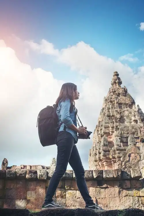 年轻迷人的女人摄影师的背包来的游客