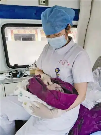 图为120护士陈香抱着刚出生的婴儿 经过反复努力施救,孩子终于有了