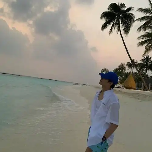 杨洋ins更新杨洋海边明信片身穿蓝色棒球帽白衬衫绿色短裤清新