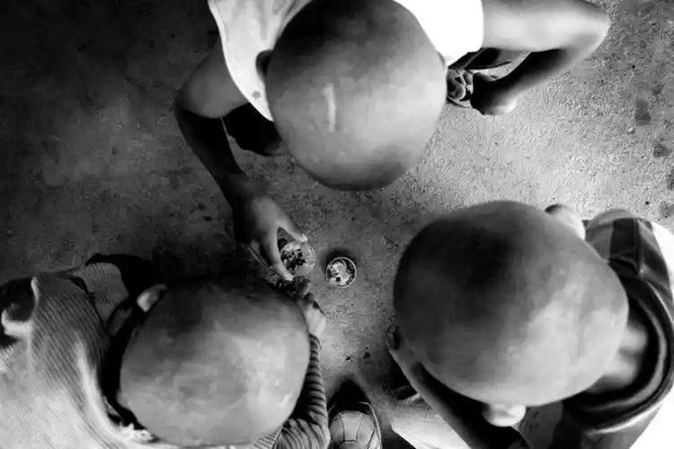 几个孩子聚在一起玩旋风卡片,这也是孤儿院孩子为数不多的小乐子.