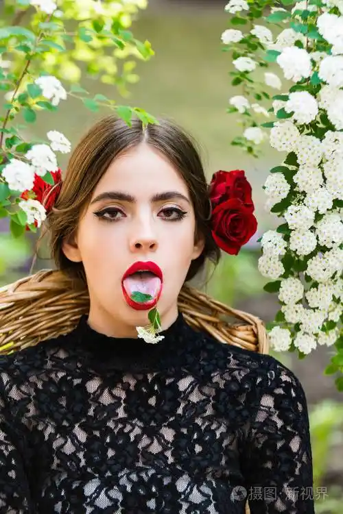 在张开嘴的舌头上的白花的可爱女人