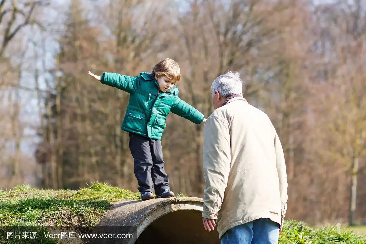 快乐的爷爷和他的小孙子在户外玩