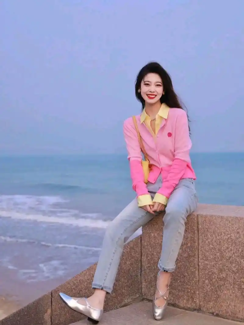 迎着海风,穿着粉色衣服和紧身牛仔的女生笑得好灿烂啊.