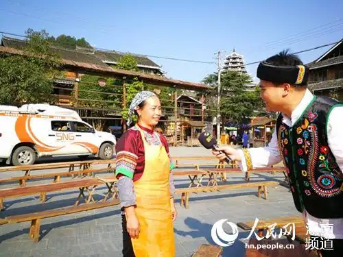 记者海瑞在怀化通道侗寨特色合拢宴的采访现场