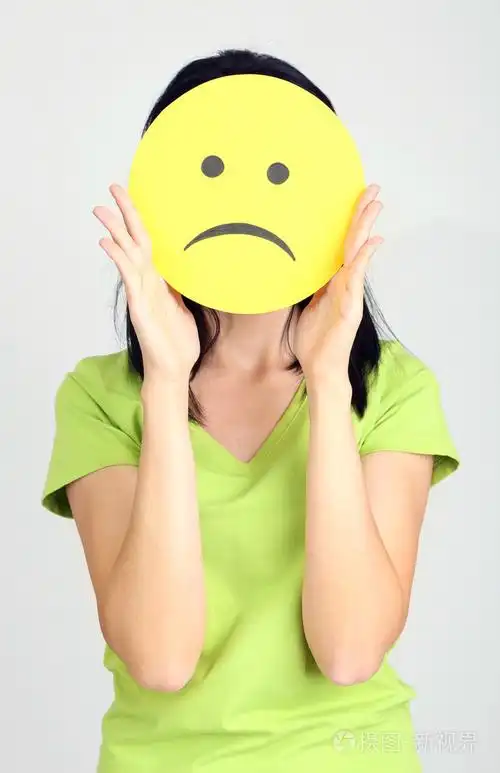 年轻女子持纸与悲伤的笑脸灰色背景