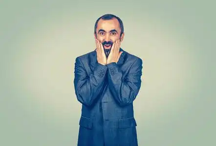 的表情快乐的成年帅哥神色惊愕,难以置信的双手捂在脸颊上张开大嘴