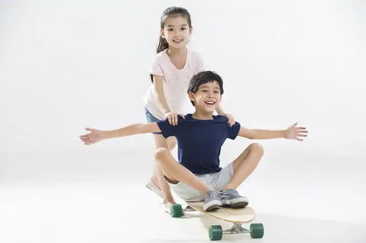 可爱的小男孩和小女孩玩滑板