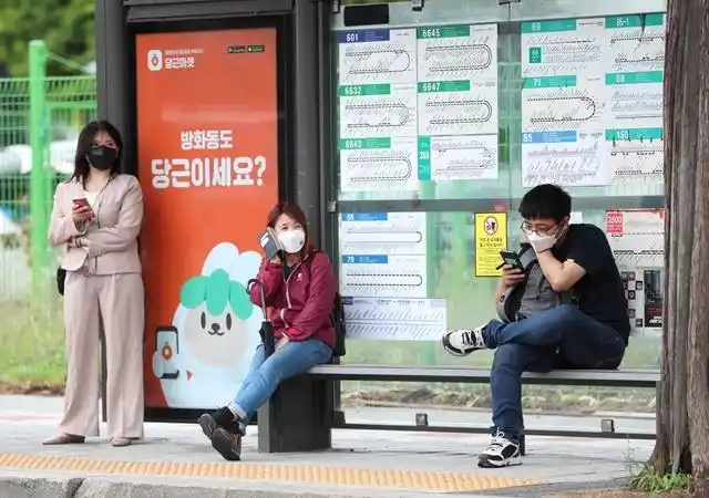 戴口罩的市民在韩国首尔一处公交站等车.新华社资料