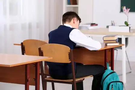 教室卫生坐姿不正确概念.小学生坐在教室的桌子前照片