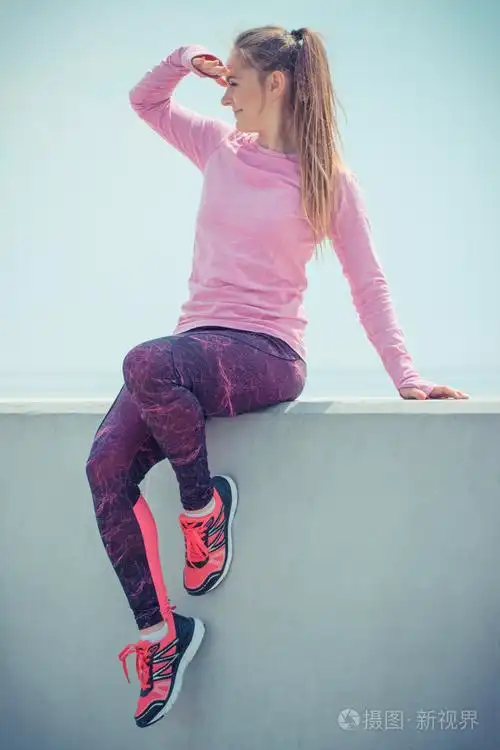 穿运动服装的女孩在运动后休息看着d