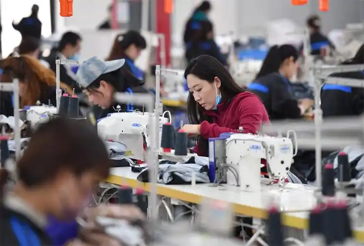 工人在延安市延川县华延服装公司车间内工作(3月31日摄).