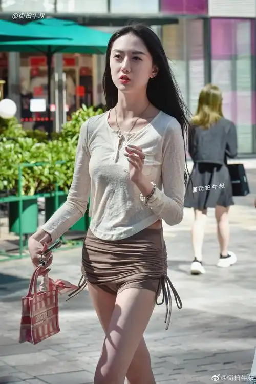 美女穿着时髦的紧身系带短裙出街