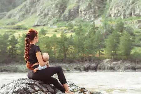 超级英雄的宝宝在玩梳辫子的小姑娘婴儿侧身站在摄像机前和向前伸手在