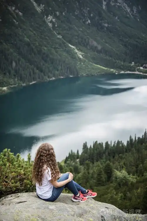 年轻妇女看山湖.湖和山的背景卷曲的女孩.tatra 国家公园, 波兰