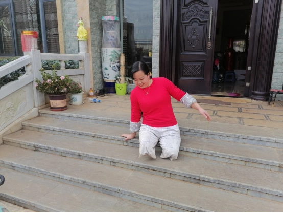 百户镇北山村委会麦田村的"板凳姐"朱琼芬是一位双腿高位截肢的残疾人