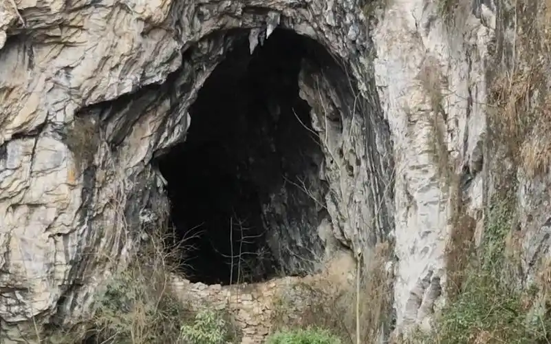 贵州深山拍到神秘山洞,洞口有一堵石墙,上面还放着一把椅子,有施工过