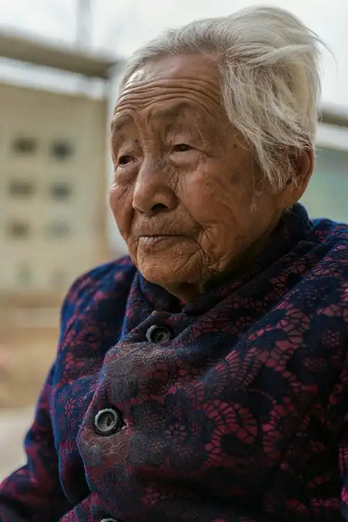 这位老母亲白发满头,一生的苦难都写在额头的皱纹里.