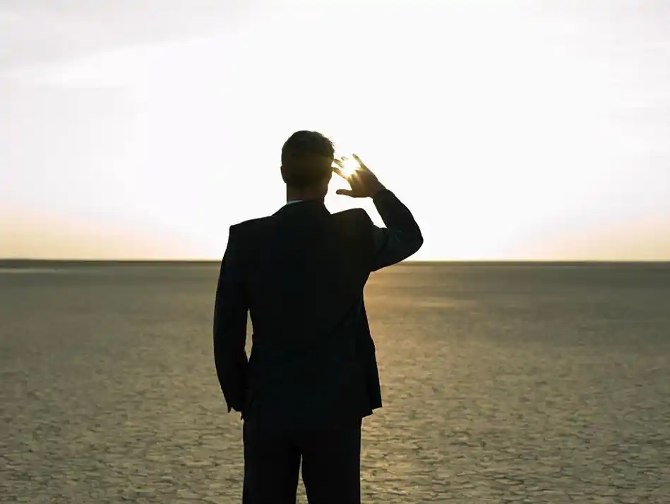 用手遮挡刺眼阳光男人背影高清图片