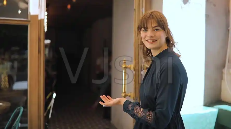 一个女人打开门,邀请进咖啡馆