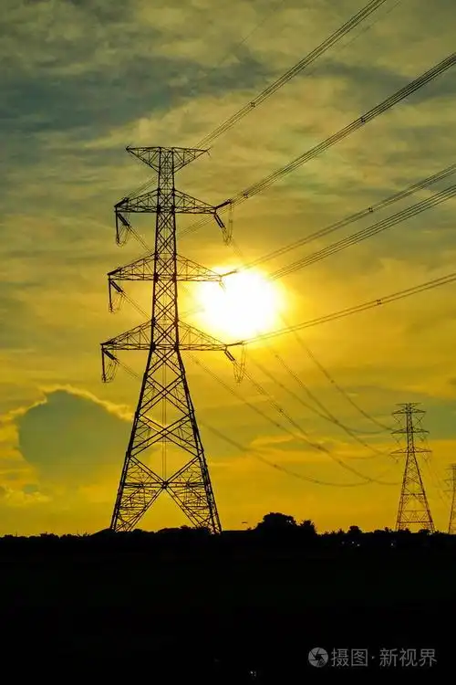 高压输电塔将电力从发电厂输送给人们. 夕阳下金色的天空