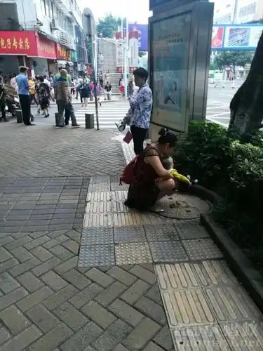 创文最关键时期,有一妇女抱娃儿在主干道上当街拉屎!