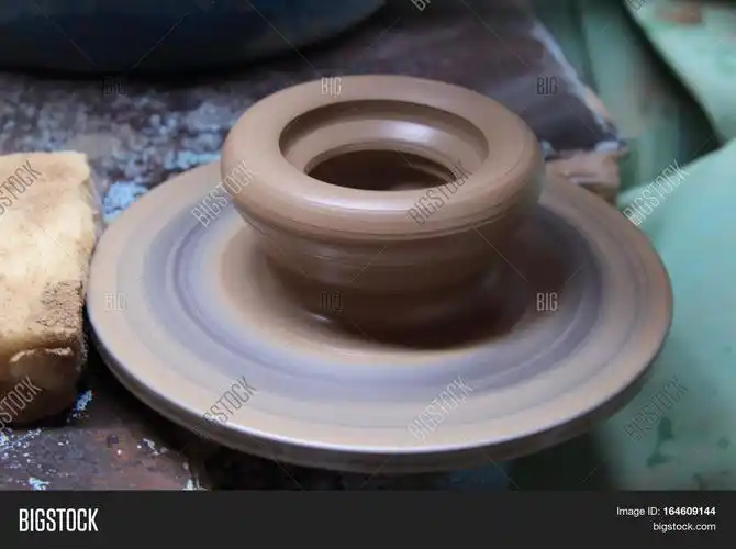 a clay pot on a pottery wheel, pottery craft, moulding the pot