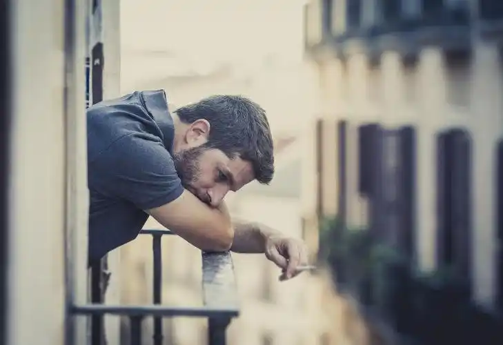 在窗户边抽烟的男人