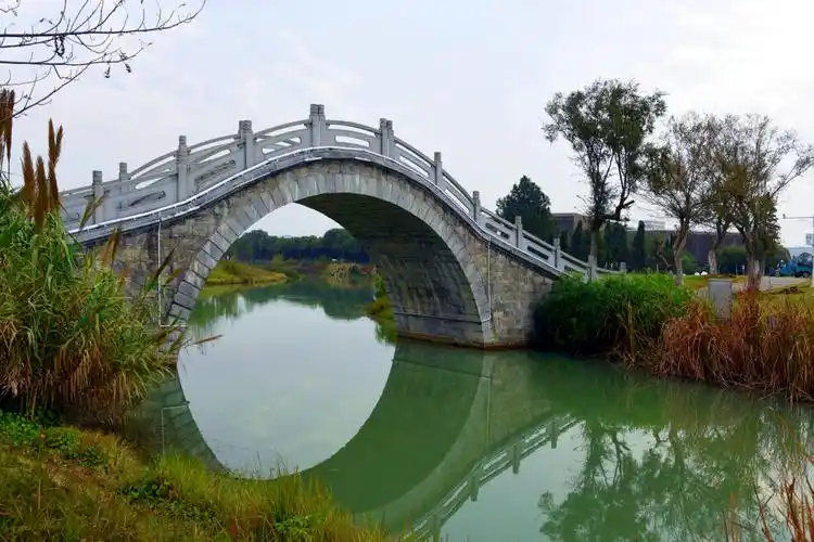 一条小河,一座石拱桥,看样子是新建的,还没有桥名.