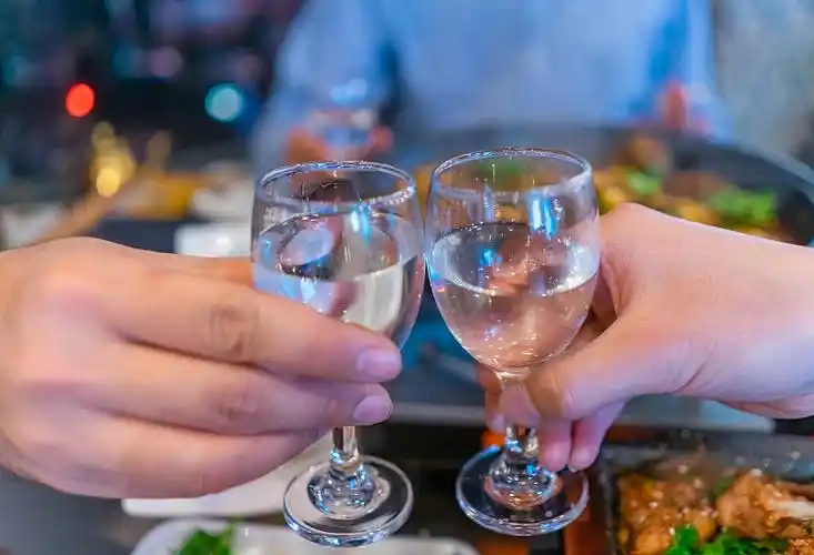 中国山东两个人端着白酒干杯瞬间图片下载