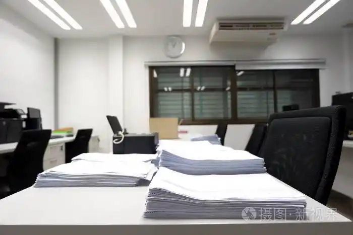 软的集中在未完成的文件和打印机放置在办公桌与模糊的空工作办公室