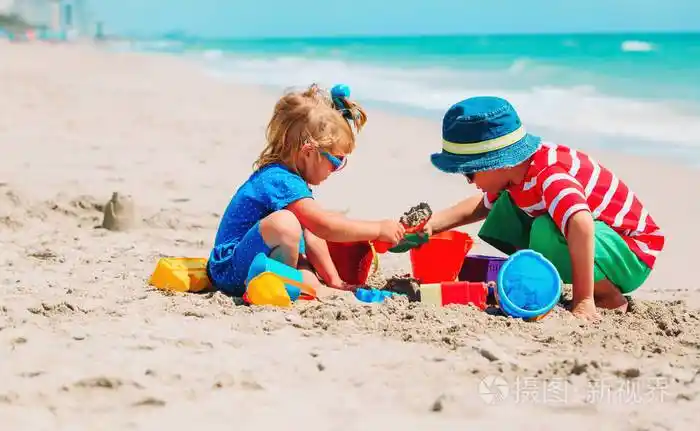 孩子们在夏天的海滩上玩沙子