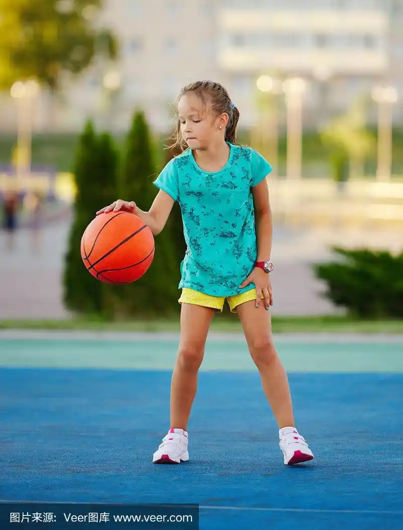 可爱小女孩在户外打篮球的照片
