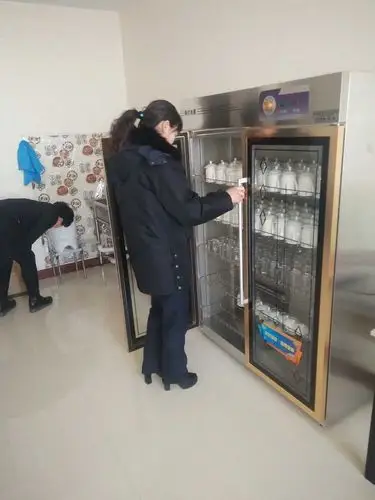 卫生监督员现场查看宾馆消毒间杯具的消毒情况