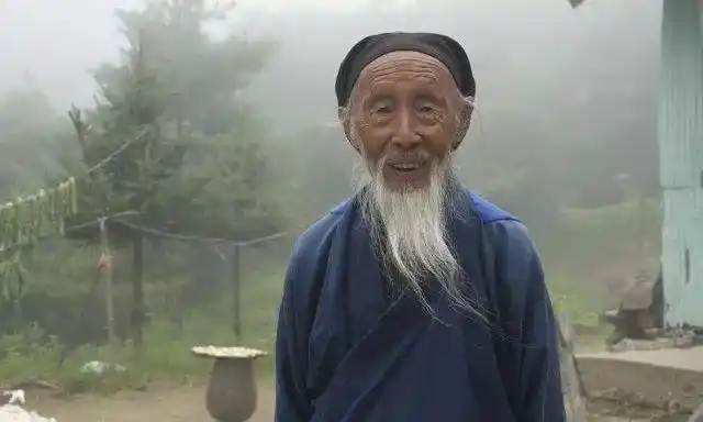 油麻菜张至顺老道长穿着满是补丁的蓝衣裤白胡子在山风里飘扬