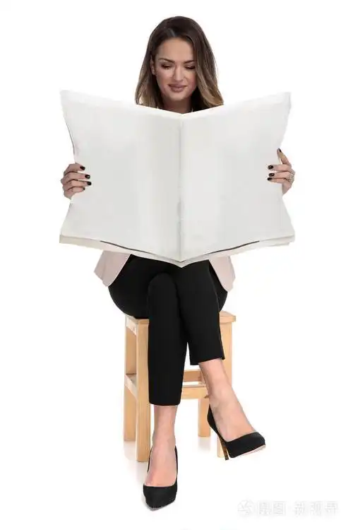 女商人坐在白色背景的木椅上双腿交叉在白色背景上阅读报纸