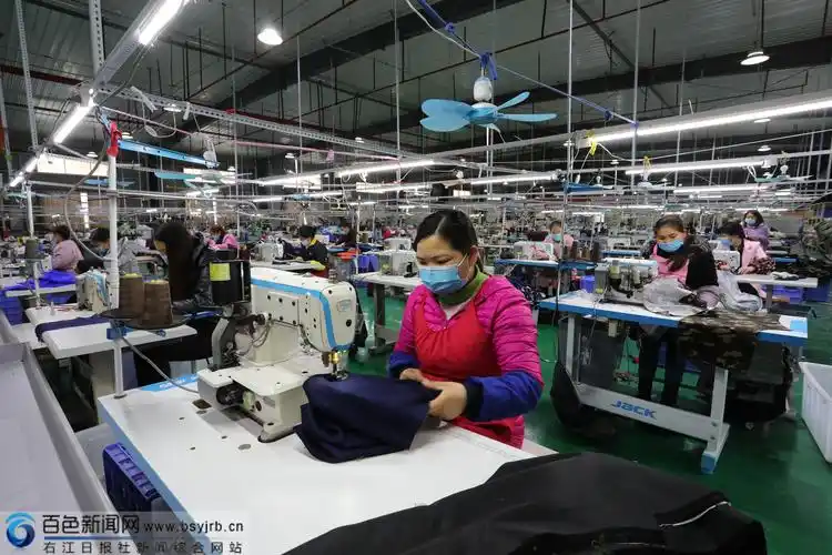 隆林昌隆服装厂车间工人在缝制服装.