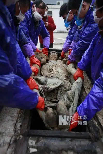 3月1日,江苏省泰州市博物馆工作人员将明代不腐女尸抬出棺外