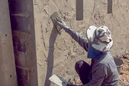 建筑墙面建筑工人用水泥浆粉刷建筑墙面油漆工在室内用伸缩辊粉刷墙壁