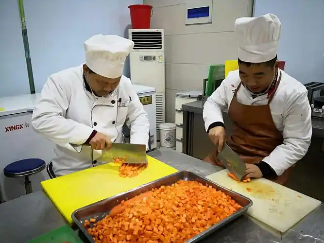 伙房人员进行切配菜品操作.