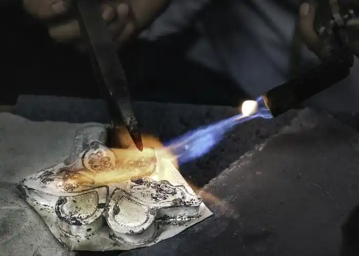 需要焊接的银饰,在接口处沾上焊药,用焊枪熔解焊接.